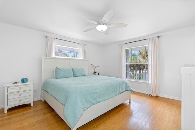 bedroom with multiple windows, ceiling fan, and light wood-type flooring