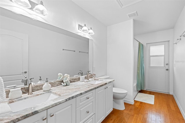 full bathroom with toilet, wood-type flooring, shower / bathtub combination with curtain, and vanity