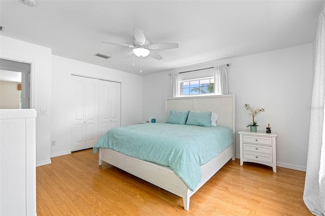 bedroom with a closet, light wood-type flooring, visible vents, and baseboards