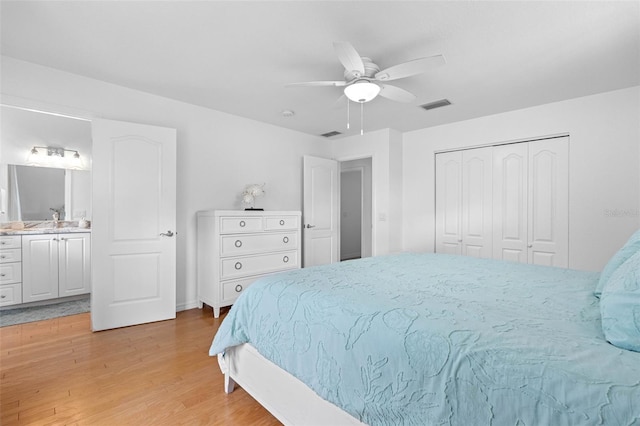 bedroom featuring visible vents, a ceiling fan, ensuite bathroom, light wood-style floors, and a closet