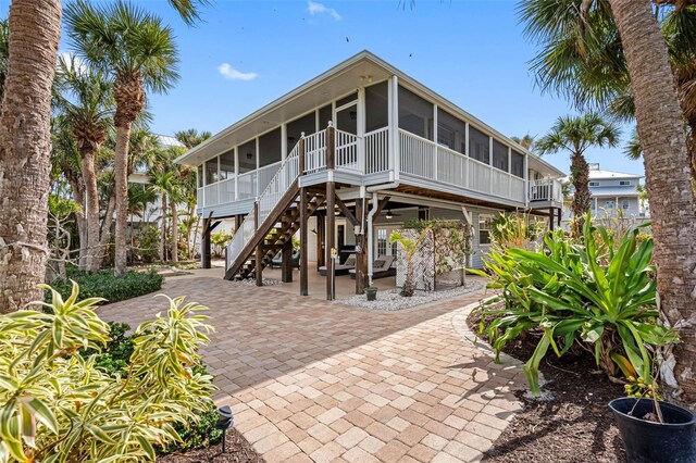 exterior space featuring a sunroom, a patio area, and stairway