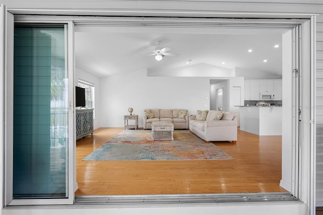 living room featuring recessed lighting, vaulted ceiling, light wood-style flooring, and ceiling fan