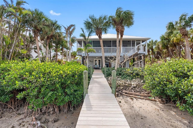 back of property featuring a sunroom and stairway