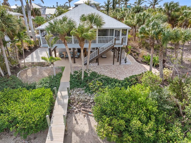 79 Palm Dr, Placida, FL 33946 - rear view of house featuring stairway, a patio, and a sunroom