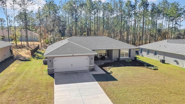 view of front of home featuring a front lawn, central AC unit, and a garage