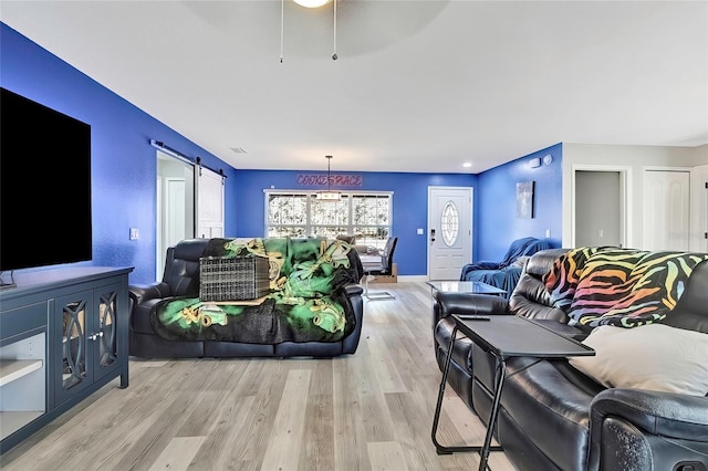 living room featuring a barn door and light hardwood / wood-style flooring