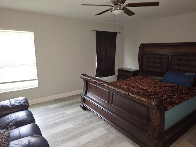 bedroom with multiple windows, ceiling fan, and light hardwood / wood-style floors