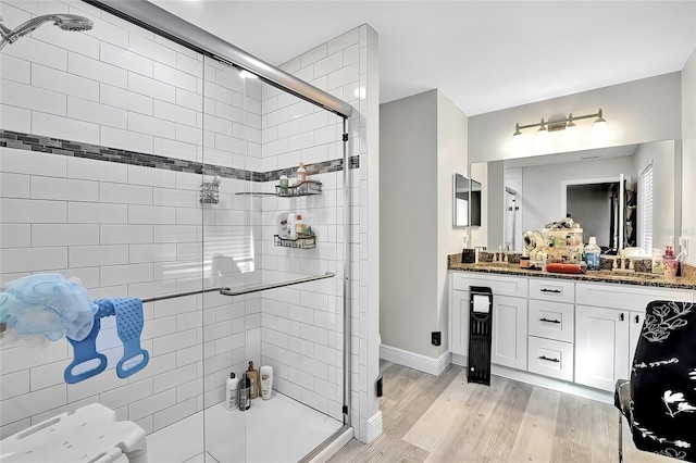 bathroom featuring vanity, a shower with shower door, and wood-type flooring