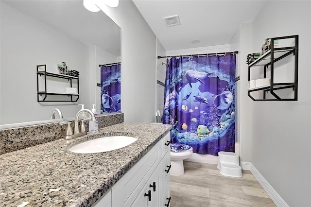 full bathroom featuring hardwood / wood-style floors, vanity, toilet, and shower / tub combo with curtain