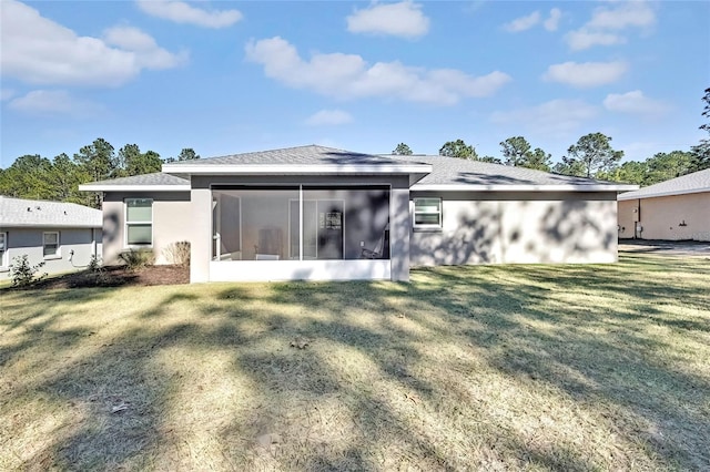 rear view of property featuring a sunroom and a yard