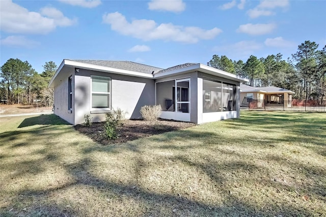 back of house with a sunroom and a yard