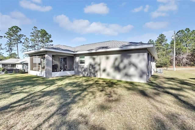 rear view of house with a lawn, cooling unit, and a sunroom