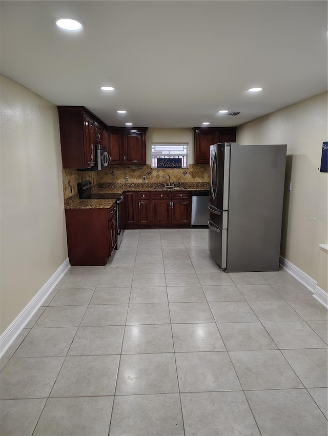 kitchen featuring dark stone countertops, sink, appliances with stainless steel finishes, and tasteful backsplash