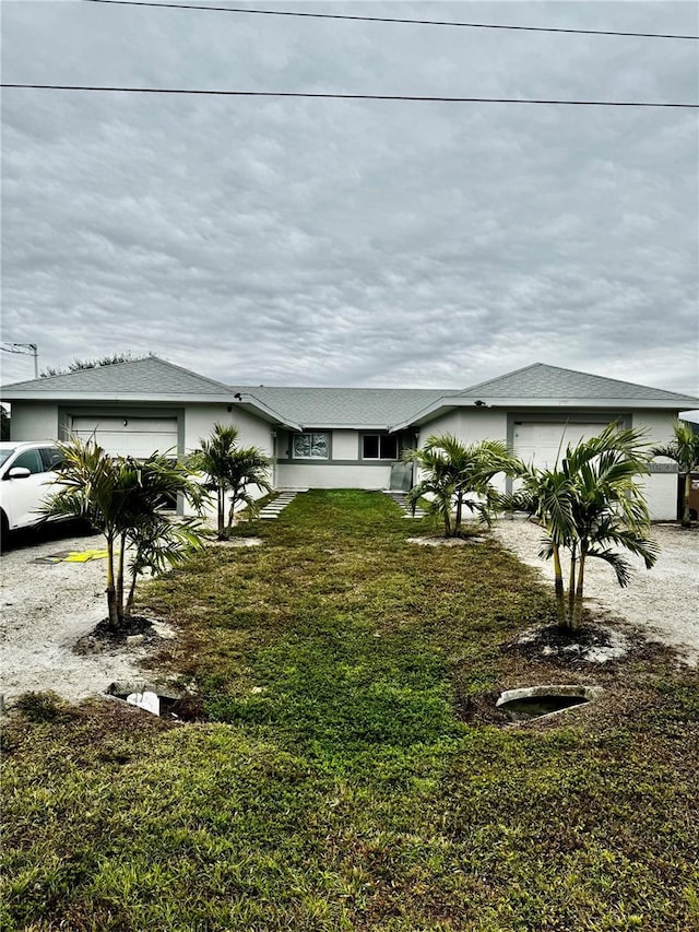 view of front of home with a garage and a front lawn