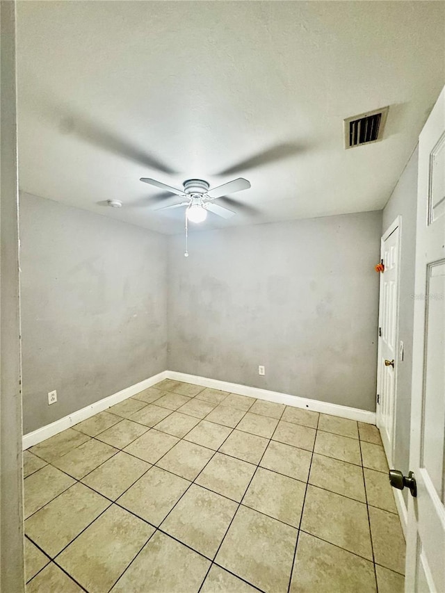 spare room with ceiling fan and light tile patterned floors