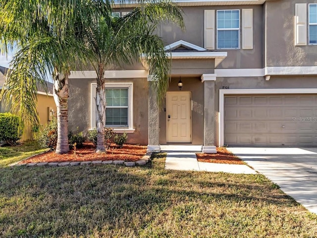 view of front of property with a garage and a front lawn