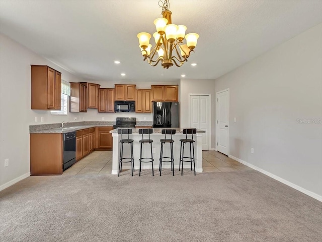 kitchen featuring light carpet, a breakfast bar, black appliances, a kitchen island, and hanging light fixtures