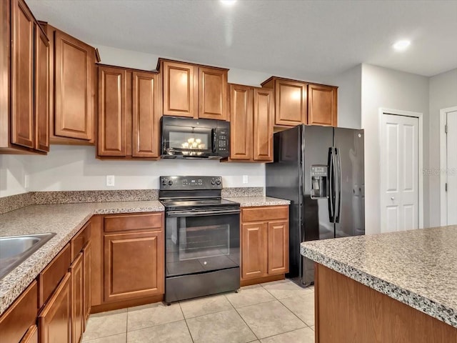 kitchen featuring light tile patterned floors, sink, and black appliances