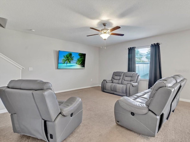 living room featuring light carpet, ceiling fan, and a textured ceiling