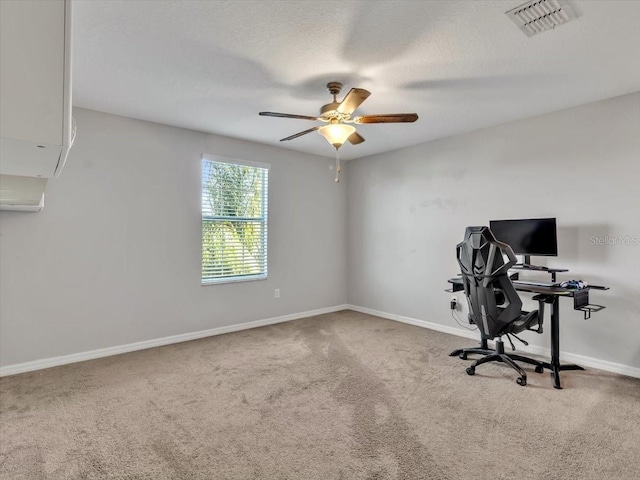 unfurnished office featuring a textured ceiling, carpet floors, and ceiling fan