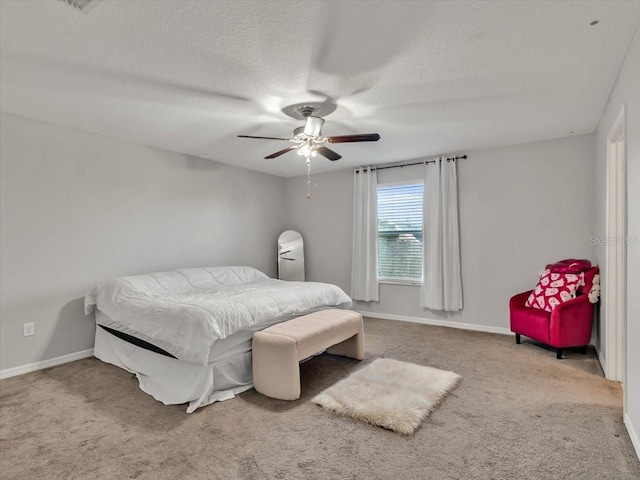 carpeted bedroom with ceiling fan and a textured ceiling