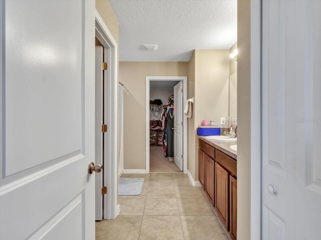 bathroom with tile patterned floors, vanity, and a textured ceiling