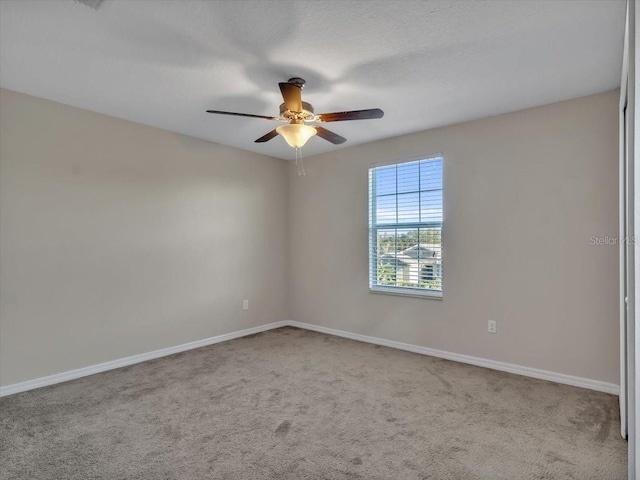 carpeted spare room with ceiling fan