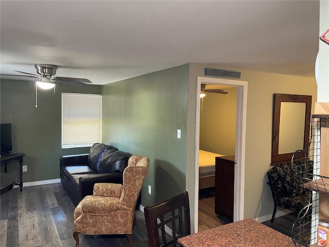 living room with ceiling fan and dark wood-type flooring