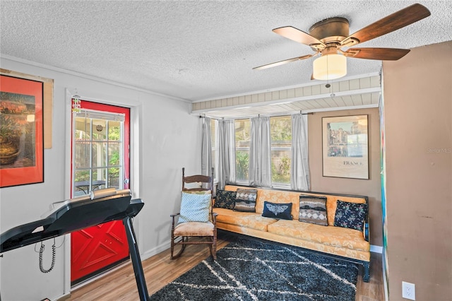 sitting room with ceiling fan, a healthy amount of sunlight, a textured ceiling, and wood-type flooring