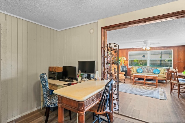 office space with hardwood / wood-style floors, ceiling fan, and wood walls