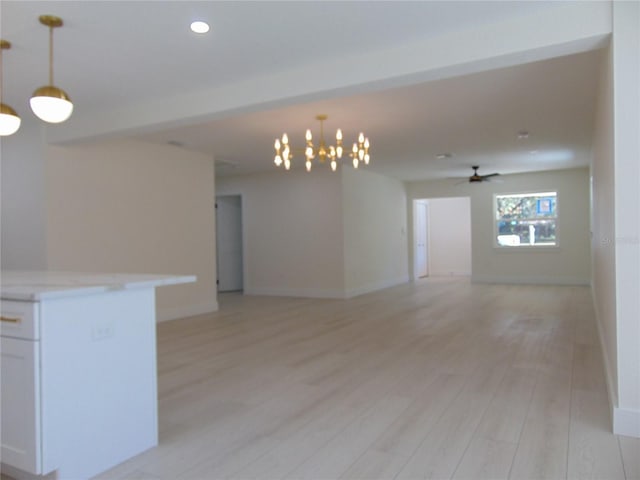 unfurnished room featuring ceiling fan with notable chandelier and light hardwood / wood-style floors