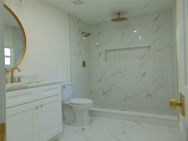 bathroom featuring toilet, vanity, and tiled shower