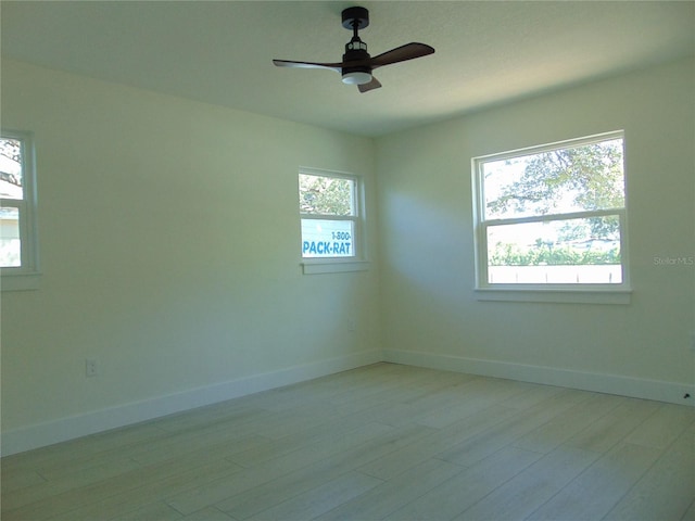 unfurnished room with a wealth of natural light, light wood-type flooring, and ceiling fan