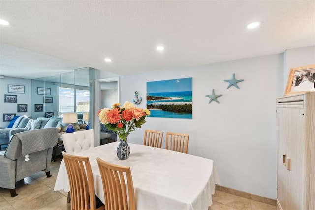 dining room featuring light tile patterned floors and a textured ceiling