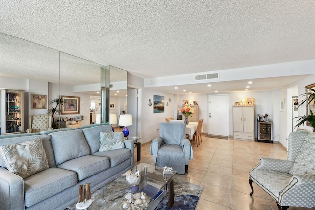 tiled living room featuring wine cooler and a textured ceiling