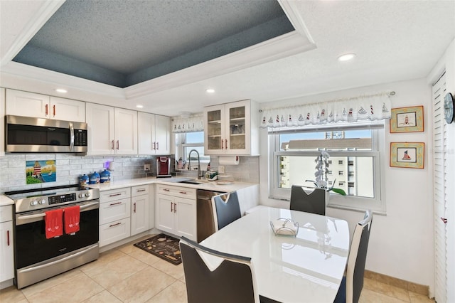 kitchen with white cabinetry, appliances with stainless steel finishes, and a raised ceiling