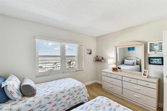 bedroom featuring light hardwood / wood-style flooring and a textured ceiling