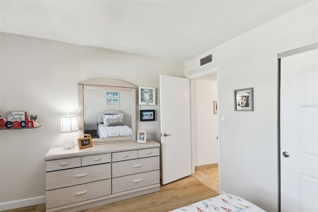 bedroom featuring a textured ceiling and light wood-type flooring