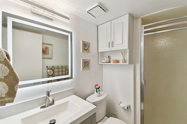 bathroom with vanity, toilet, and a shower with door