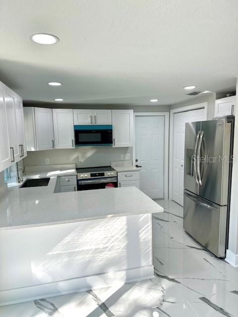 kitchen featuring white cabinets, appliances with stainless steel finishes, kitchen peninsula, and sink