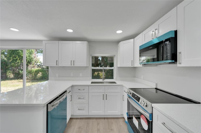 kitchen with white cabinets, light wood-type flooring, sink, and appliances with stainless steel finishes