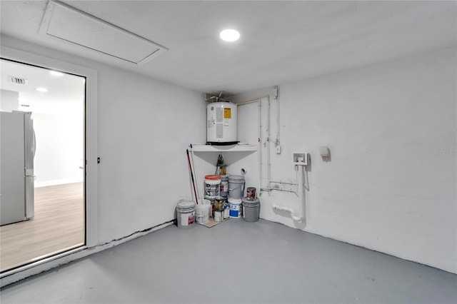 garage featuring electric water heater and stainless steel refrigerator