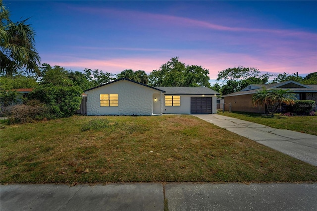 single story home featuring a yard and a garage