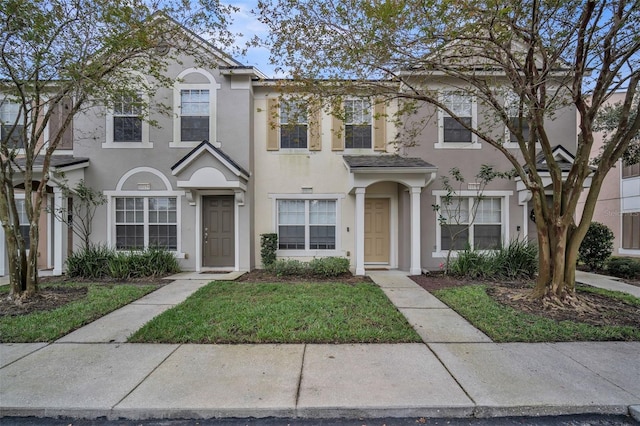 townhome / multi-family property featuring a front yard