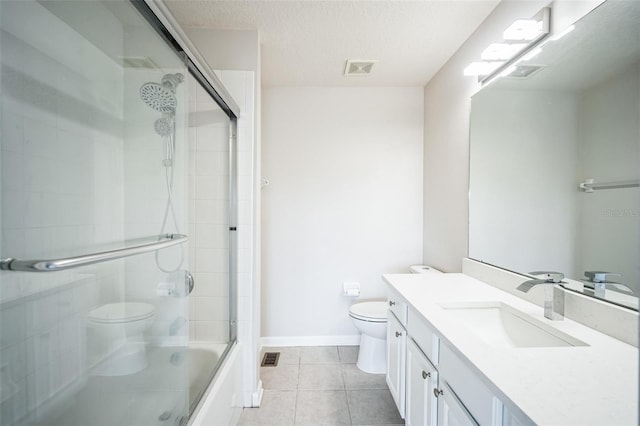 full bathroom featuring vanity, toilet, shower / bath combination with glass door, and a textured ceiling