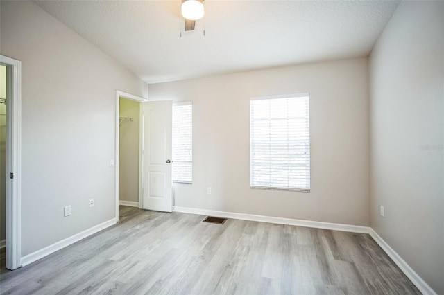 spare room featuring a textured ceiling, light hardwood / wood-style floors, and ceiling fan