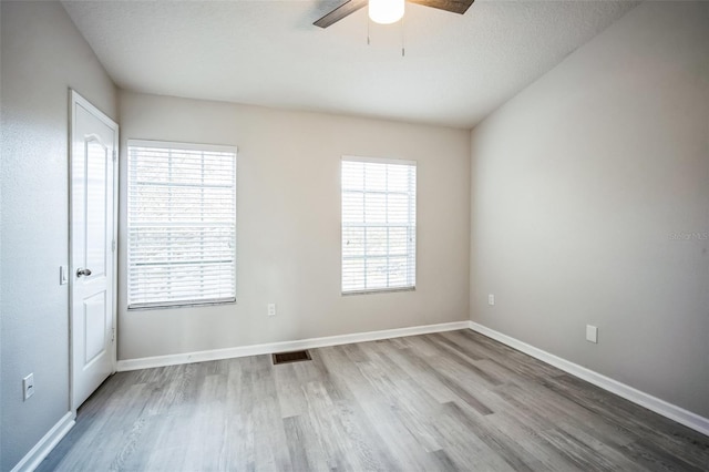 spare room featuring ceiling fan, a textured ceiling, and light wood-type flooring