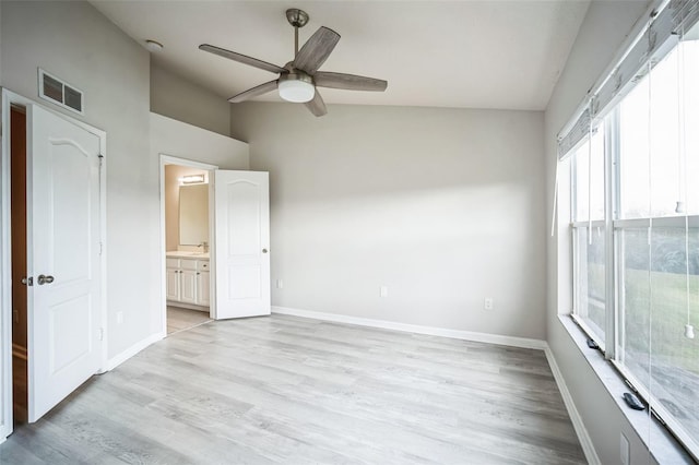 empty room featuring ceiling fan, light wood-type flooring, sink, and vaulted ceiling