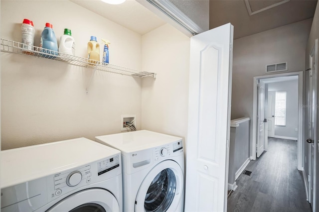 clothes washing area with dark wood-type flooring and washing machine and clothes dryer