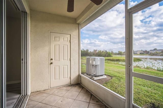 unfurnished sunroom featuring ceiling fan, plenty of natural light, and a water view